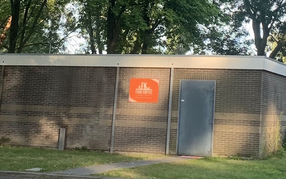 Het studiogebouw aan de Indigostraat met het oranje bord van Feride Kurttas op de gevel